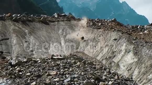 缓慢运动的落石接近在岩石山脉的背景下大石头从融化的冰川落下视频的预览图