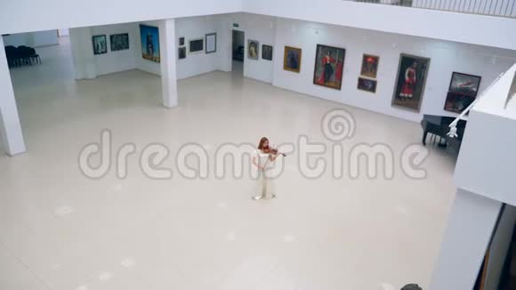 宽敞的画廊大厅一位女士拉小提琴视频的预览图