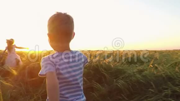 日落时两个孩子在田野里奔跑视频的预览图