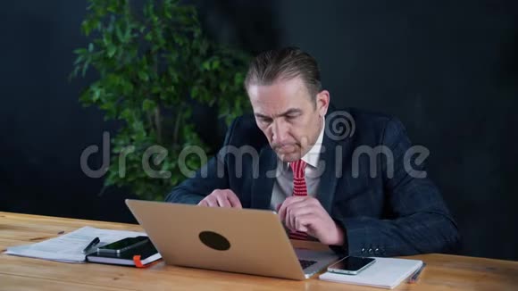 坐在笔记本电脑前工作的商人或律师视频的预览图