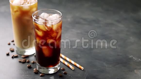 黑色背景上的两杯冷咖啡咖啡加冰淇淋或牛奶慢动作视频的预览图
