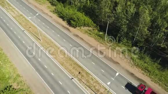 红色卡车沿着公路向远处的城市移动视频的预览图