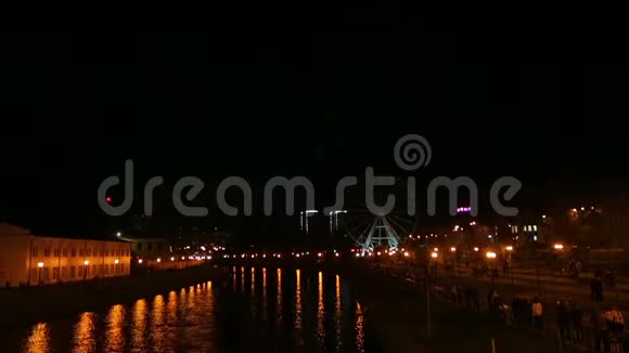 光明美丽的烟花在城市的堤岸上在夜空的摩天轮的背景下是视频的预览图