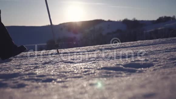 徒步旅行者在冬天寒冷的雪天徒步旅行在山脉的背景下腿沿着山脊走视频的预览图