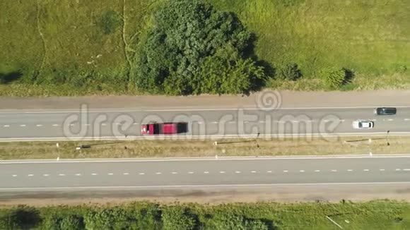 红色空车卡车沿着现代道路行驶经过田野上景视频的预览图
