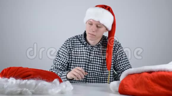 戴着圣诞帽子的年轻人看着圣诞老人的裤子视频的预览图