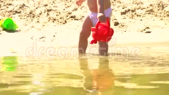 沙滩上的小女孩在玩水壶视频的预览图