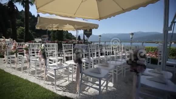 在意大利举行的带有鲜花和装饰品的公开仪式上的白色结婚椅视频的预览图