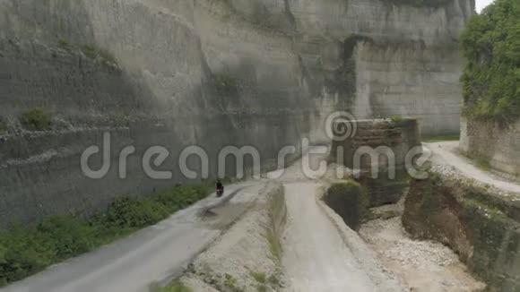 在UluwatuBali海滩和岩石的公路上骑自行车视频的预览图