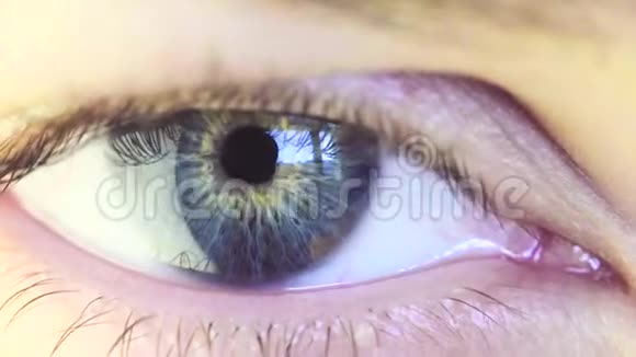 一个美丽的年轻女人的蓝眼睛看着窗户视频的预览图