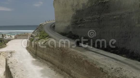 在Uluwatu巴厘岛海滩和岩石上的公路上骑自行车视频的预览图