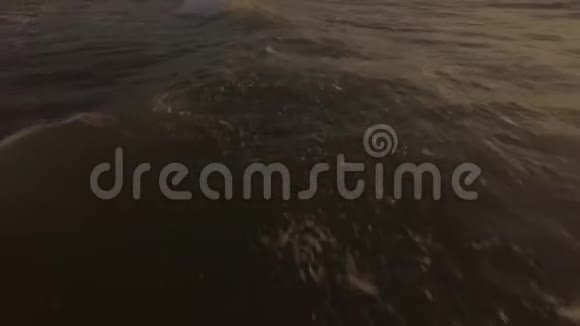 清晨日出时海浪拍打在海岸上来自海上飞行无人机的空中景观视频的预览图