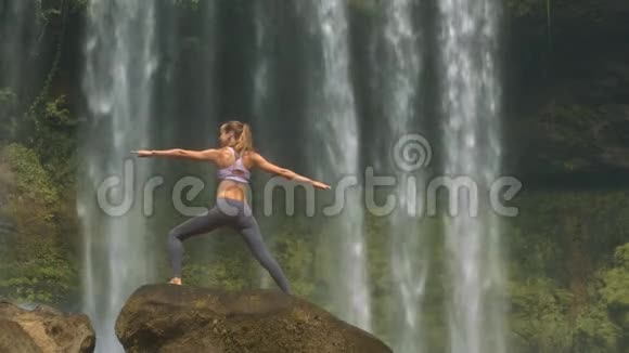 瘦女孩玫瑰在圆石对瀑布视频的预览图