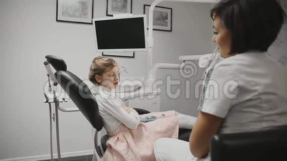 儿童牙医我办公室里的小女孩进行咨询医生和一个女孩谈论视频的预览图