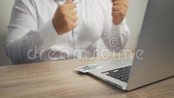 网上购物概念男人手拿信用卡用笔记本电脑信用卡在桌子上视频的预览图