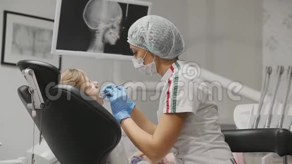 牙医检查牙套一个小女孩检查牙齿是否有龋齿牙医办公室视频的预览图