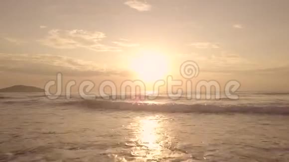 金色的太阳在五彩缤纷的天空中日落在海上溅起水波无人驾驶的视野日出初期的空中景观视频的预览图