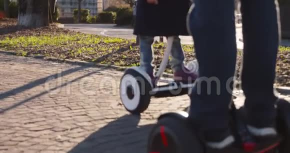 赛格威细节与女儿孩子和爸爸骑马现代未来运输技术积极的家庭公园人行道视频的预览图