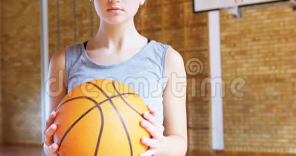 在球场上拿篮子球的少女视频的预览图