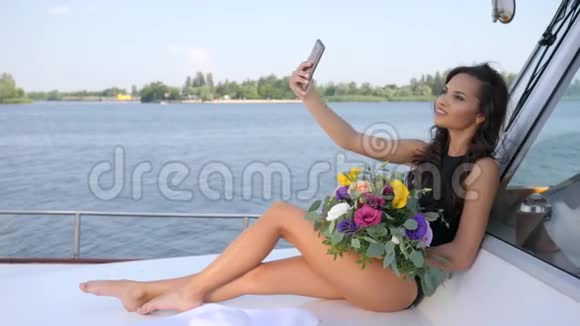 年轻女子在游艇上自拍夏天休息时双手捧花视频的预览图