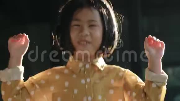 亚洲儿童头戴电话听音乐的肖像视频的预览图