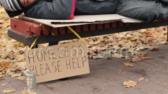 慈善善良的人把钱放在长凳上无家可归的男人睡觉视频的预览图