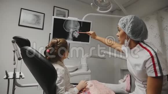 办公室牙医正畸牙医显示x光图像的牙齿并持有建议和支架视频的预览图