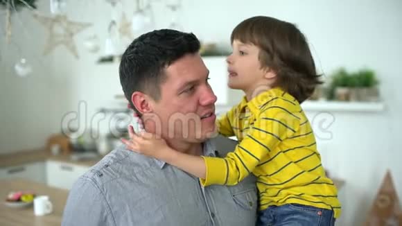 儿子和父亲的肖像英俊的年轻父亲把他的小儿子抱在怀里一个幸福的家庭父亲节慢慢慢慢视频的预览图
