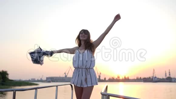 夏天的周末在夕阳下的海面上一位手持布挥舞着船头的女性视频的预览图