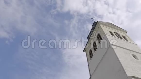 在阳光明媚的日子里教堂塔行动蓝天背景下的白色教堂尖塔视频的预览图