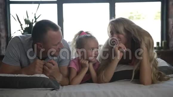 爱的父母亲吻躺在床上的女儿视频的预览图