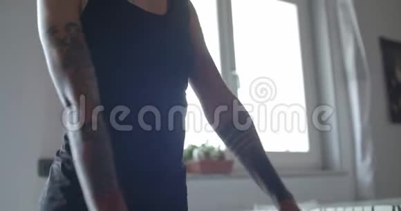 年轻的纹身女人在家庭健身运动锻炼中做深蹲运动家庭客厅视频的预览图