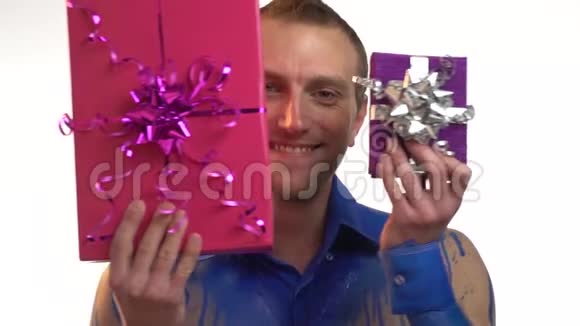 一个穿着蓝色紧身衣的男人注视着礼物和微笑动作缓慢视频的预览图