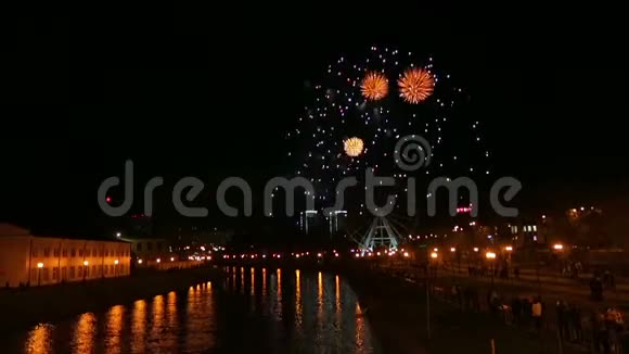 在摩天轮的映衬下城市的堤岸上放着明亮美丽的烟花视频的预览图