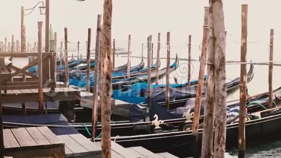 在意大利威尼斯古老的木墩上美丽的传统空船在波浪上摇摆视频的预览图