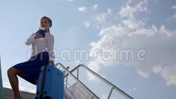 空姐在机场的楼梯上背着行李箱和护照视频的预览图