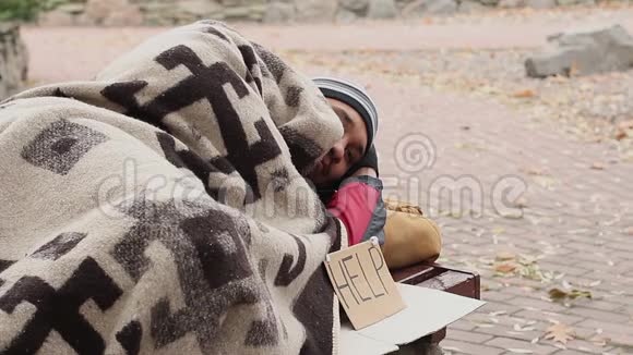 体贴的流浪汉躺在公园的长凳上有帮助标志乞讨贫穷视频的预览图