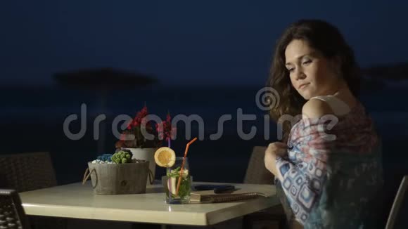 调情的年轻女士抚摸头发享受户外海边餐厅的休息视频的预览图
