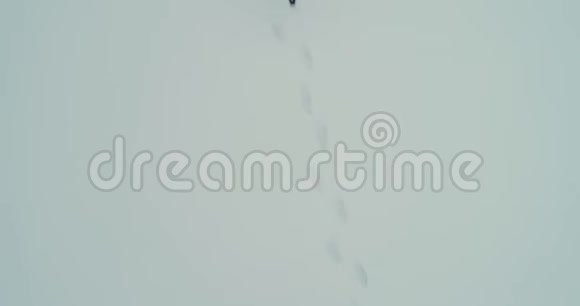 人们的腿在雪上行走在雪天留下脚印视频的预览图
