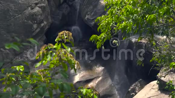 落石瀑布流淌在山林中山瀑溅在绿林中的大石头上岩石流视频的预览图