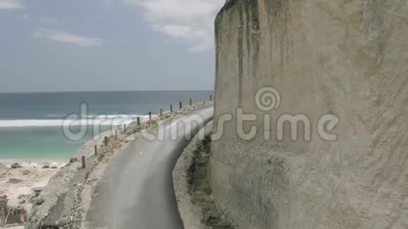在UluwatuBali海滩和岩石的公路上骑自行车视频的预览图