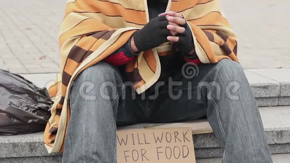 一个人在公园里准备为食物标志工作无家可归的乞讨贫穷悲伤视频的预览图