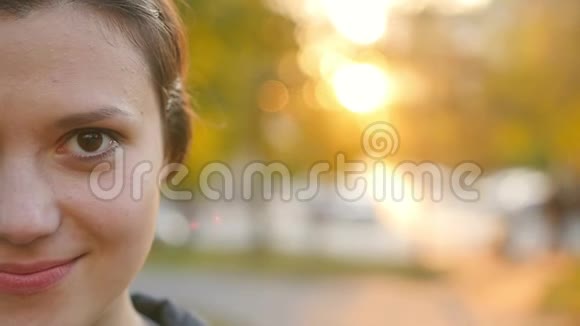 一位可爱的年轻女子在日落时在公园里欣赏秋天的肖像布鲁内特在秋天公园的背景视频的预览图