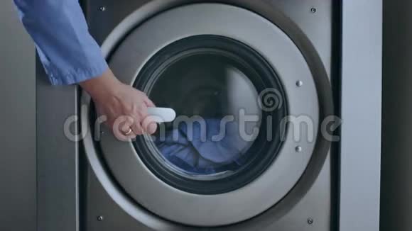 女性手拿洗衣衣工业洗衣烘干机特写视频的预览图