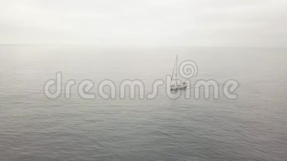 孤帆船放下帆在海上航行背景下天空阴沉视频的预览图