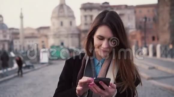 年轻快乐的女人在城市里散步使用智能手机女孩浏览互联网在意大利罗马度假视频的预览图