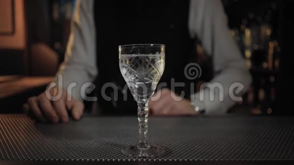 调酒师在干马提尼鸡尾酒中加入橄榄视频的预览图