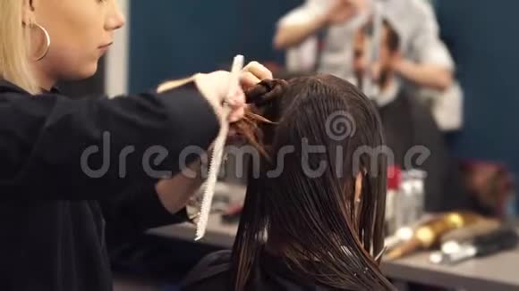 漂亮的女人梳湿头发发型师在沙龙里刷女人的头发美容师为顾客服务专业人员视频的预览图