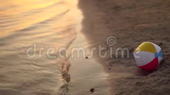 海滩球落在日落时的海滨视频的预览图
