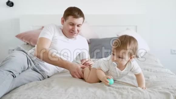 慈爱的父亲正在和他的孩子玩耍在假期里在卧室里抚摸他的头视频的预览图